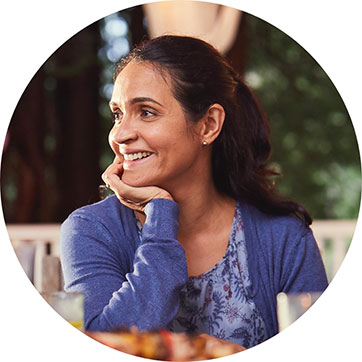 woman smiling at table with food and drinks on it